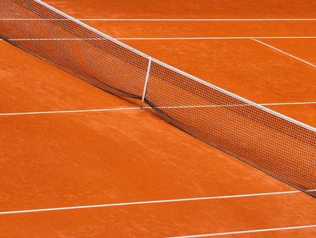 Vibrant Clay Tennis Court Bathed in Warm Sunlight with a Perfectly Taut Net, A Striking Scene of Athletic Elegance and Natural Beauty, Ideal for Sports Enthusiasts and Timeless Spoの写真素材