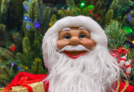 Santa Claus doll with Christmas tree and gift box on the background.