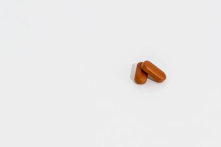 two brown pills, isolated on whiteの写真素材