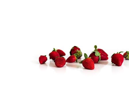Bright red fresh ripe strawberries berries scattered and isolated on a white background.の写真素材