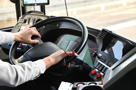 Driver driving public transport. Only his hands are visible. Both his hands lie on the driver's...