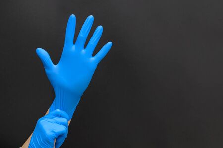 The girl has both hands in blue protective gloves. Filming the process of putting gloves on the left...