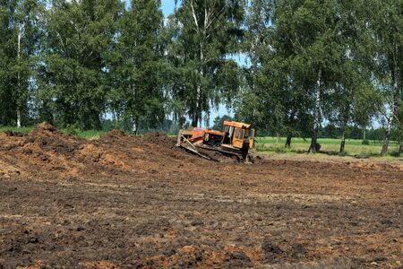 Bulldozer shaping hill for new house