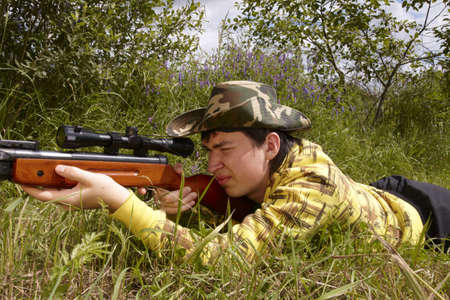 Young hunter shooting upの写真素材