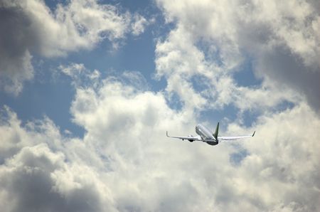 Airplane flies by through clouds.