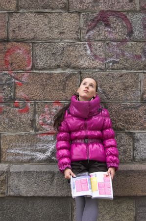 The girl in a pink jacket with a magazine.の写真素材