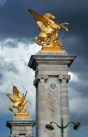 Columns with gilded sculptures symbolise war and agriculture on the bridge Alexandre III in Paris, France.の写真素材