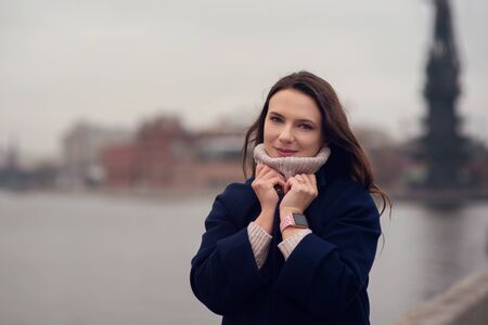 Autumn portrait of a beautiful young girl walking in the city center.の写真素材
