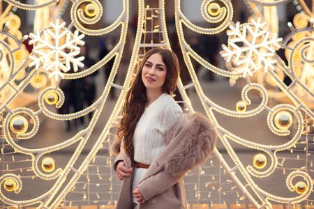 christmas portrait of happy girl holding burning sparkler or firework outdoor, snowy winter...