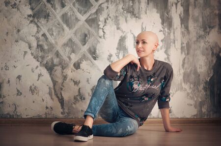 Portrait of beautiful middle woman patient with cancer with shaved head without hair. Emotions, hope in the eyesの写真素材