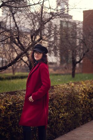 Portrait of a happy and proud pregnant woman looking at her belly in autumn parkの写真素材