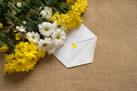 Bouquet of camomiles at burlap background with leaves.の写真素材