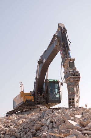 Excavator over a heap of rubblesの写真素材