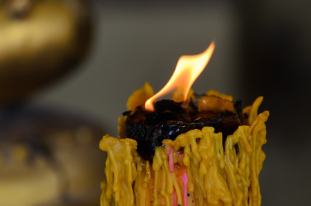 Candle flame burning bright. The image has been zoomed during exposure creating the halo of light with rays of light from the candle. Fucus candle and light.の写真素材