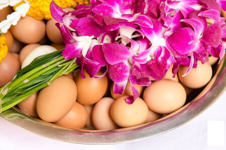 Group of fresh eggs and flower in a bowl.