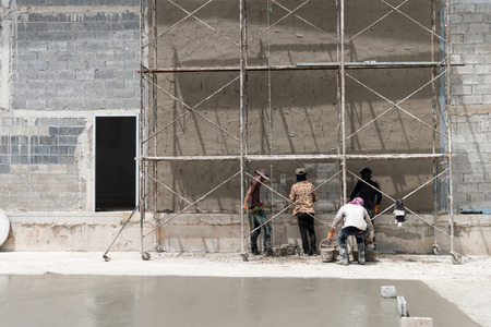 Close up of industrial bricklayer installing cement on construction siteの写真素材