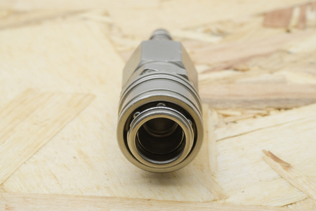 Air coupling connector, Pneumatic fitting on wood background.