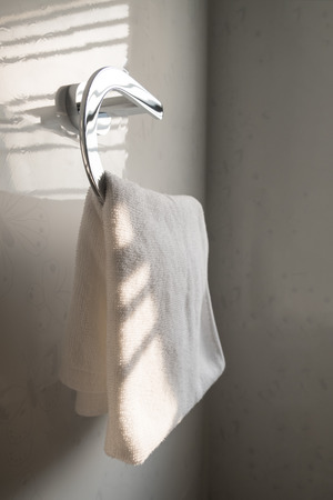 White clean towel on the steel shelf in bathroom.の写真素材