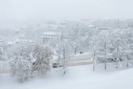 Snowstorm in the city. People are standing at a bus stop in a blizzardの写真素材