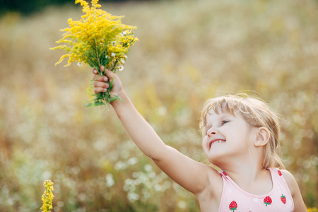 Sweet little girl in a meadow with wild spring flowersの写真素材