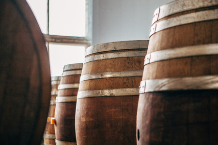 Old wooden wine barrels with iron hoops in stock.