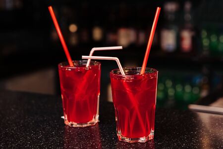 Two glasses with a red cocktail at the bar.の写真素材
