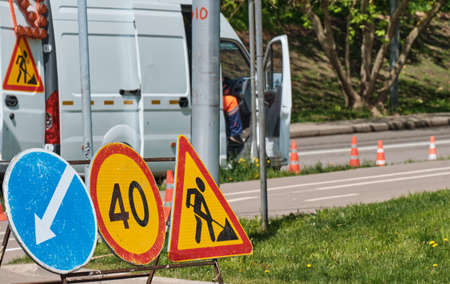 Road signs with work truck on construction road.の写真素材