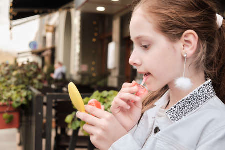 Cute teenage girl preening on city backgroundの写真素材