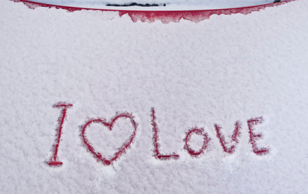 Valentine's day, I love you, Viva Magenta painted on snowy car hood.の写真素材