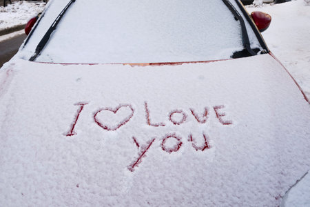 Valentine's day, I love you, Viva Magenta painted on snowy car hood.の写真素材