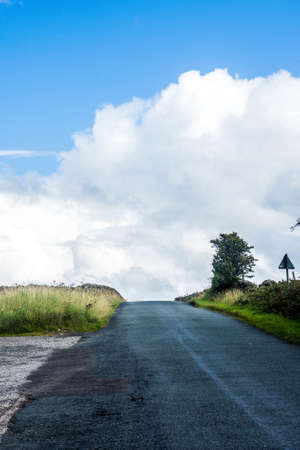 A road in Lancashire reaches the top of a steep hill.の写真素材