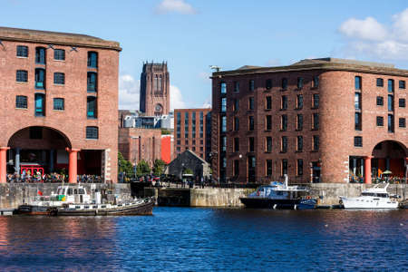 The tower of the Liverpool Anglican Cathedral between two dockside buildings.のeditorial素材