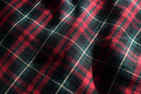 Green and Red Tartan Material Fabric with Sunlight and Shadows Highlighting Details and Patterns