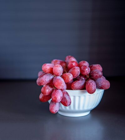 Seedless red grape isolate on dark backgroundの写真素材