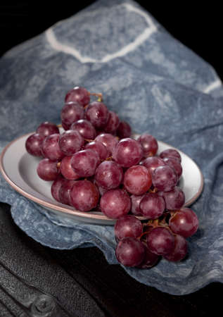 Bunch of red grape isolated on dark wood background