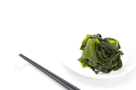 Fresh seaweed wakame on white plate isolated on white background. Japanese foodの写真素材