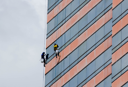 group of workers cleaning windows service on high rise buildingの写真素材