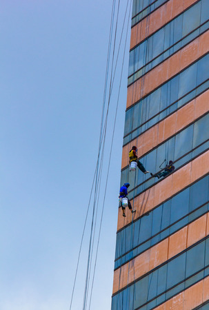 group of workers cleaning windows service on high rise buildingの写真素材