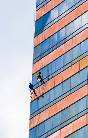 group of workers cleaning windows service on high rise buildingの写真素材