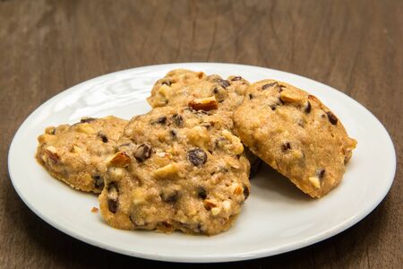 Chocolate chip cookies on plate on wooden background