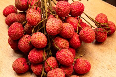 Fresh lychees isolated on wood background