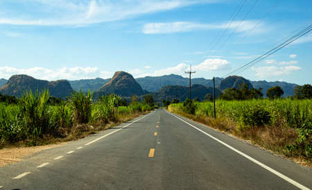 asphalt highway and hills under blue skyの写真素材