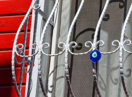 Blue round glass pendant in the form of an eye hanging on a lattice window. Traditional Turkish...