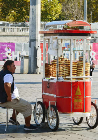 Istanbul, TURKEY, September 18, 2018. Seller of traditional Turkish bagels - simits siting next to a truck in Taksim Squareのeditorial素材