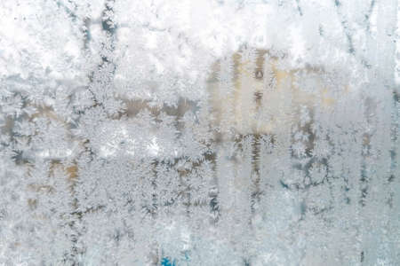 Frosty ice pattern on the glass in winter