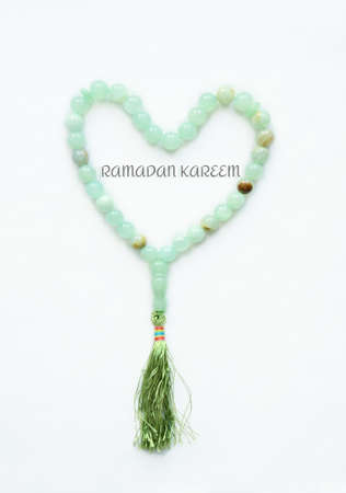 Muslim Rosary lying in the shape of a heart. The inscription is translated from Arabic to English: Generous Ramadanの写真素材
