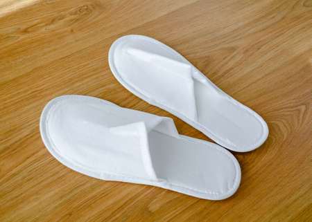 Couple new eco-friendly fabric disposable slippers on wooden floorの写真素材