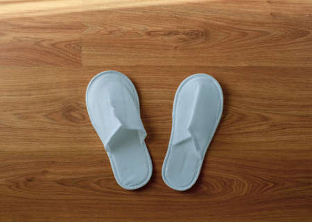 Couple new eco-friendly fabric disposable slippers on wooden floorの写真素材