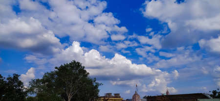 sky blue background image white clouds tree background image in indian village imageの写真素材
