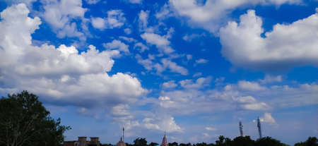 sky blue background image white clouds tree background image in indian village imageの写真素材